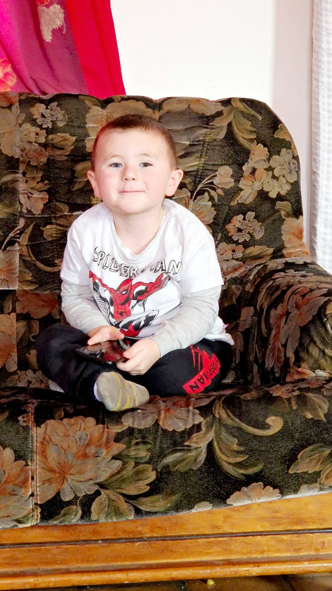 Soan participe au concours pour gagner de l'argent avec cette photo : baby, baby_toddler_clothing, child, curtain, event, flooring, fun, grass, happy, head, joy, mammal, pattern, person, sitting, sleeve, smile, t_shirt, toddler, tree