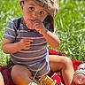 toddler, child, grass, outdoor, cap, food, snack, blanket, toy, baby_bottle, sunlight, casual_clothing, summer, cute, sitting, playing, nature, barefoot, portrait, daytime