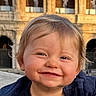 Eden a rejoint le concours — aidez-le/la à gagner de superbes lots ! toddler, child, smile, face, blue_eyes, blond_hair, sweater, portrait, outdoor, historic_building, stone_arch, sunlight, golden_hour, happy, cute, closeup, person, young_child, expression, warm_light
