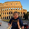 Eden a rejoint le concours — aidez-le/la à gagner de superbes lots ! child, toddler, smiling, person, adult, hands, colosseum, rome, landmark, historic, outdoor, sunset, sky, building, tourist, travel, street, bus, architecture, happy