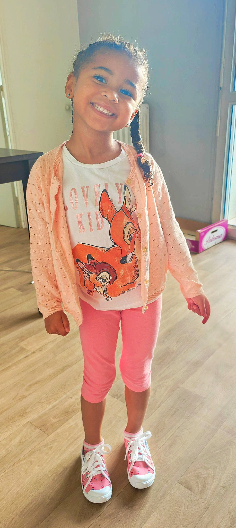 Mayla participe au concours pour gagner de l'argent avec cette photo : active_pants, baby_toddler_clothing, chest, face, fashion, flooring, happy, head, joint, joy, necklace, orange, person, pink, sleeve, smile, sportswear, standing, t_shirt, thigh