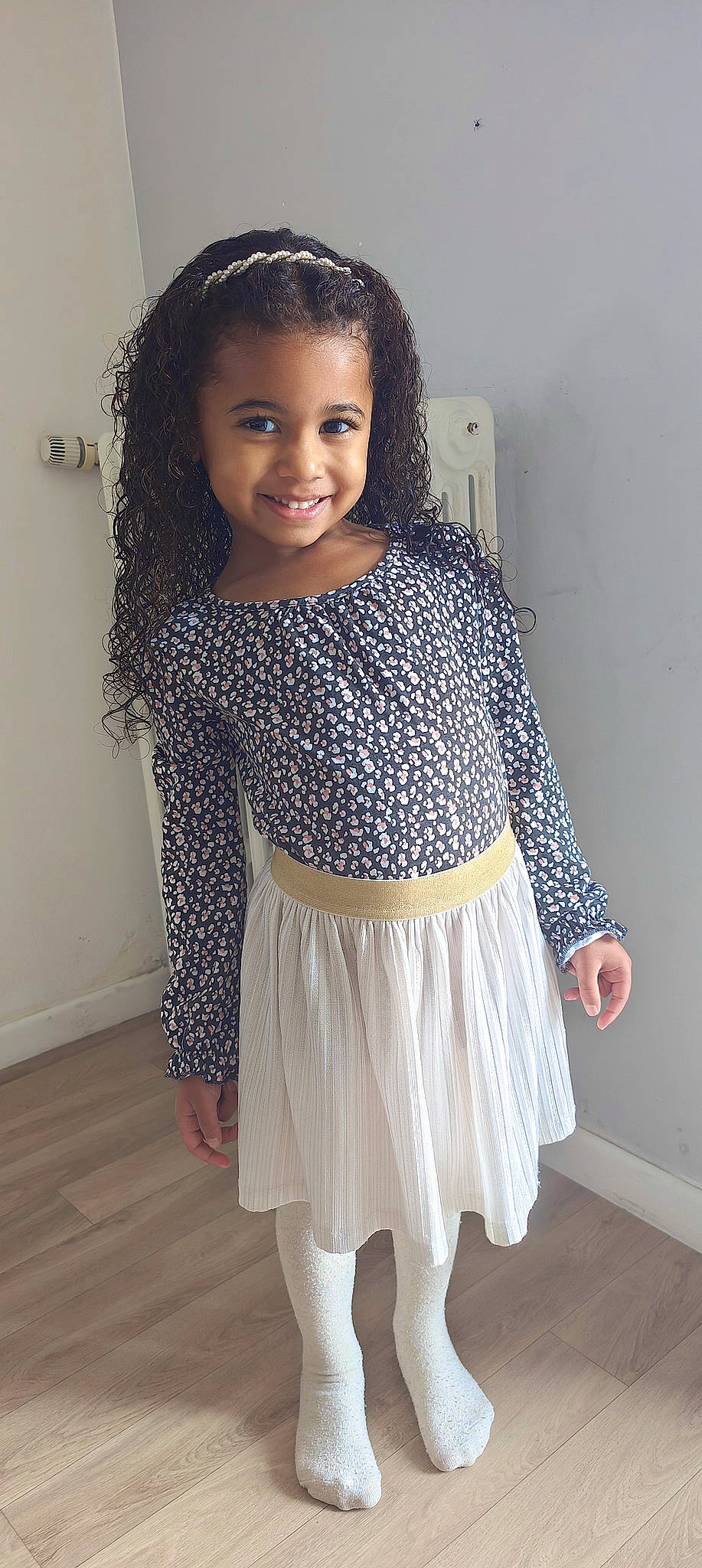 Mayla a rejoint le concours — aidez-le/la à gagner de superbes lots ! baby_toddler_clothing, day_dress, embellishment, face, fashion_design, flooring, hair, happy, human_body, joy, knee, neck, pattern, person, shoulder, sleeve, smile, thigh, toddler, trunk
