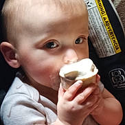Xander joined the competition — help win amazing prizes! baby, child, ice_cream, cone, hand, face, eyes, car_seat, warning_label, close_up, food, cute, infant, light, skin, mouth, clothing, indoor, person, snack