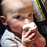 baby, child, ice_cream, cone, hand, face, eyes, car_seat, warning_label, close_up, food, cute, infant, light, skin, mouth, clothing, indoor, person, snack