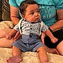 baby, infant, child, person, sitting, clothing, shirt, shorts, suspenders, barefoot, blanket, adult, hands, couch, indoor, portrait, cute, curious, soft, cozy