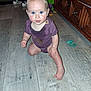 Tessa joined the competition — help win amazing prizes! baby, child, blue_eyes, purple_onesie, wooden_floor, indoor, curious, sitting, toys, shoes, furniture, cabinet, flooring, person, infant, young_child, looking_up, home, candid, casual
