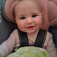 Tessa is registered to the contest to win money with this photo: baby, child, car_seat, seatbelt, blanket, polka_dots, smile, blue_eyes, pink, clothing, infant, cute, portrait, indoor, young_child, sitting, face, head, comfort, soft