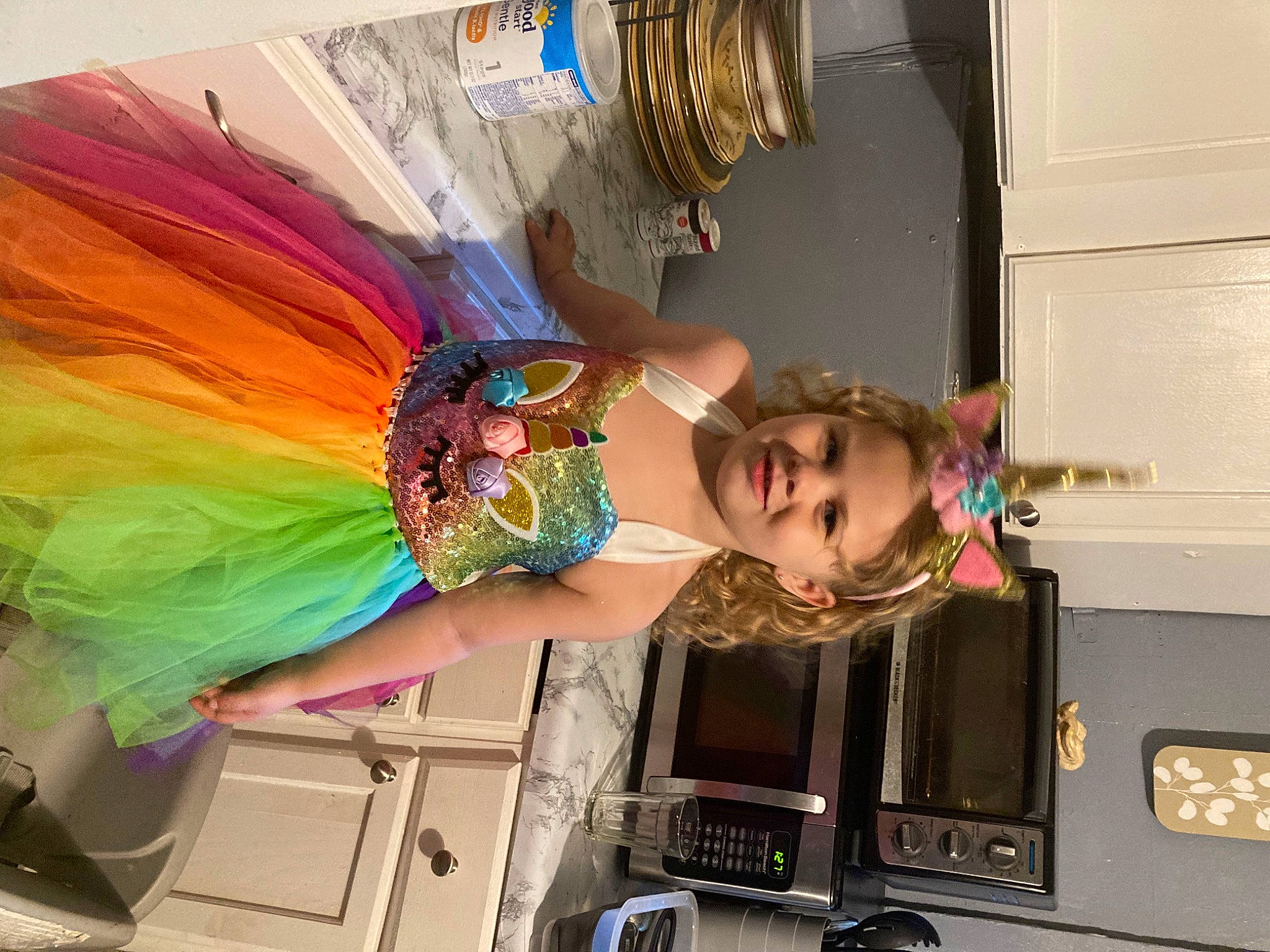 Amira is registered to the contest to win money with this photo: art, child, curtain, dress, event, fashion_design, feather, fun, home_appliance, joy, kitchen, kitchen_appliance, machine, magenta, major_appliance, person, product, room, smile, toddler