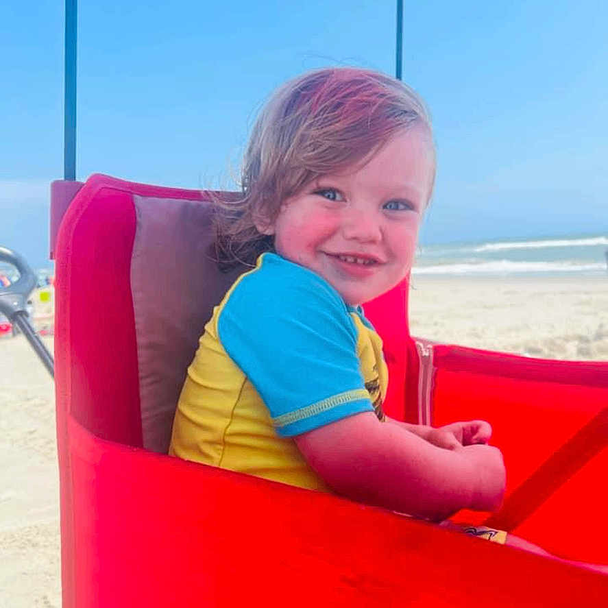 Jaxson joined the competition — help win amazing prizes! architecture, baby, beach, building, clothing, coast, face, head, nature, outdoors, person, photography, portrait, sea, shelter, shoreline, sky, summer, t_shirt, water