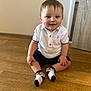 Cobie is registered to the contest to win money with this photo: toddler, child, boy, sitting, floor, white_polo_shirt, socks, blue_eyes, wooden_floor, indoor, cute, smiling, short_hair, casual_clothing, happy, person, baby, portrait, young_child, home