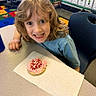 Koltyn joined the competition — help win amazing prizes! blue_shirt, chair, child, classroom, cookie, curly_hair, cute, desk, education, food, frosting, happy, indoor, napkin, person, school, smiling, sprinkles, table, young_child
