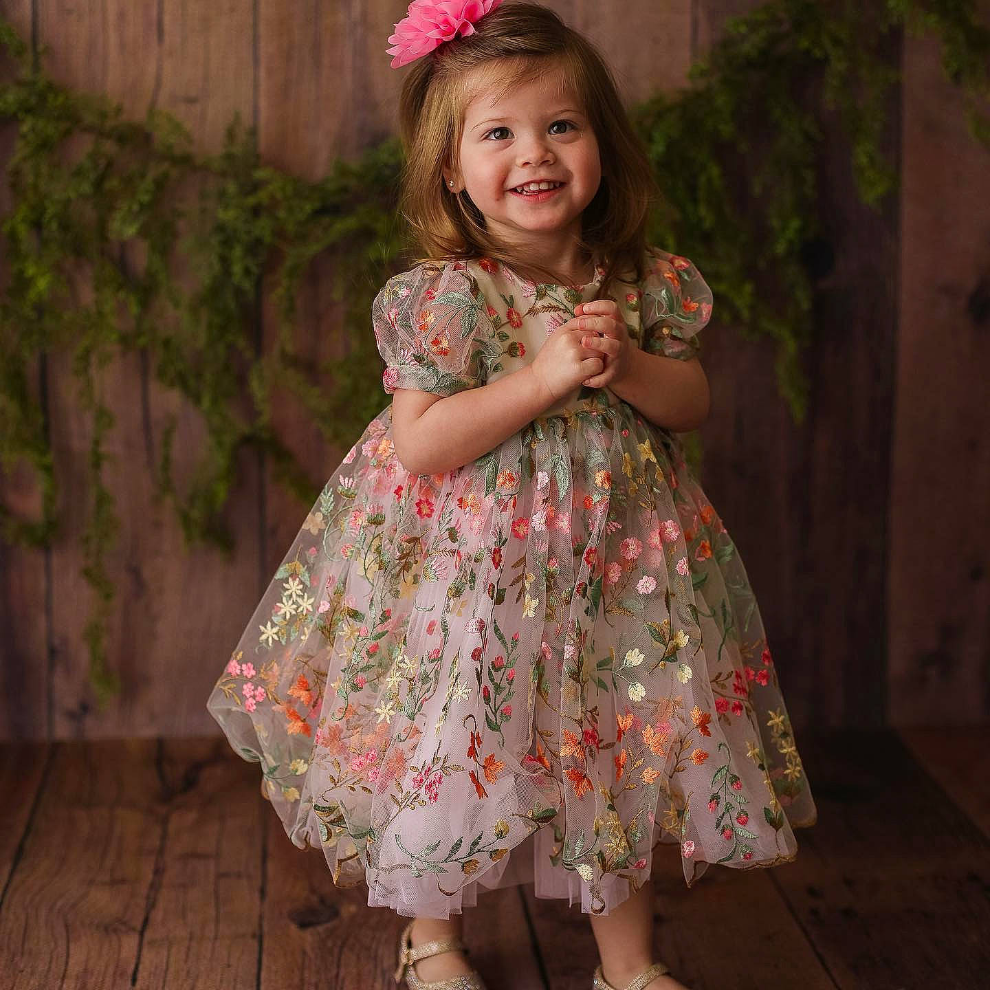 Esther is registered to the contest to win money with this photo: baby_toddler_clothing, day_dress, dress, embellishment, fashion_design, footwear, grass, happy, headgear, joy, neck, one_piece_garment, person, pink, plant, shoe, skin, sleeve, smile, standing