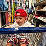 Michael is registered to the contest to win money with this photo: aisle, baby, casual_wear, child, clothing_store, colorful_clothes, cute, fashion, happy, indoor, person, red_cap, retail, seat, shopping, shopping_cart, shorts, smiling, toddler, white_shirt