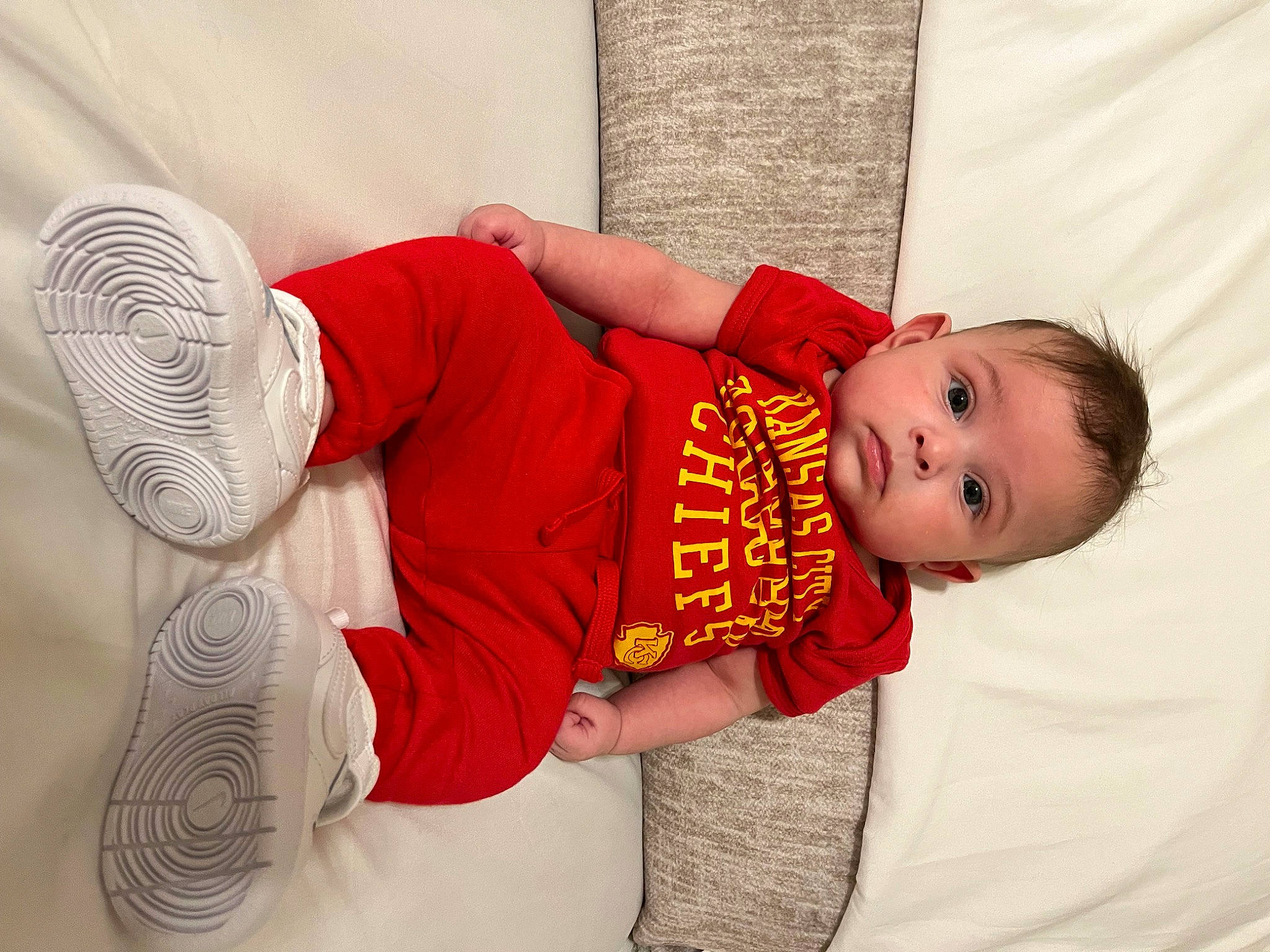 Enzalo is registered to the contest to win money with this photo: baby, baby_toddler_clothing, child, comfort, couch, elbow, finger, flash_photography, floor, flooring, happy, human_leg, leg, linens, pattern, person, sitting, sleeve, t_shirt, toddler