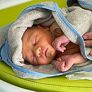 Maylo a rejoint le concours — aidez-le/la à gagner de superbes lots ! newborn, baby, sleeping, towel, hand, skin, infant, resting, closeup, soft_texture, blue_trim, green_background, peaceful, cute, wrapped, person, human, tiny, portrait, fresh
