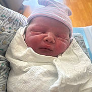 Emmett is registered to the contest to win money with this photo: newborn, baby, infant, swaddled, blanket, hat, sleeping, face, hospital, bed, pattern, soft_light, closeup, child, portrait, cute, resting, skin, headwear, indoor