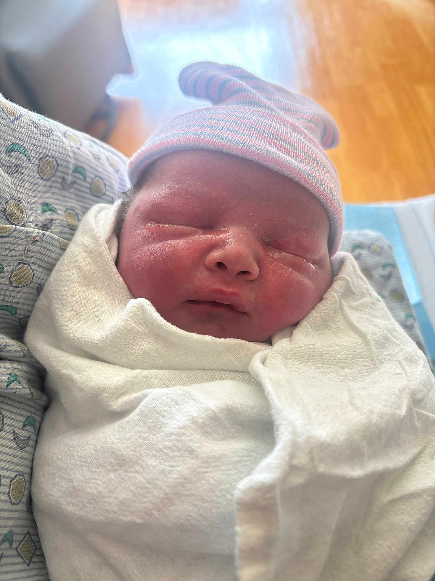 Emmett is registered to the contest to win money with this photo: newborn, baby, infant, swaddled, blanket, hat, sleeping, face, hospital, bed, pattern, soft_light, closeup, child, portrait, cute, resting, skin, headwear, indoor