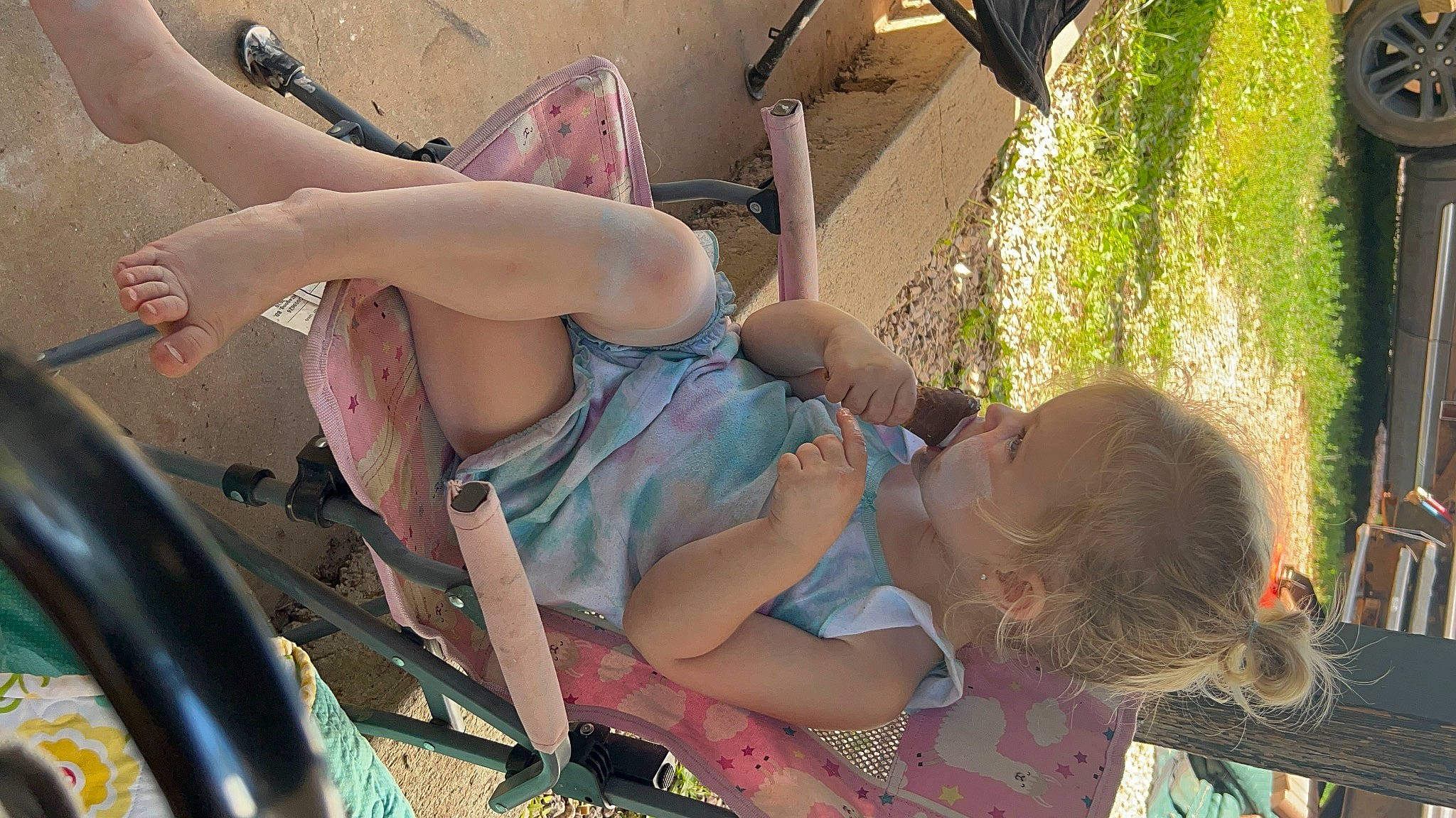 Tinlee is registered to the contest to win money with this photo: baby, black_hair, brassiere, chair, child, eyewear, fun, grass, happy, human_body, human_leg, leisure, people_in_nature, person, recreation, sandal, sitting, summer, thigh, toddler