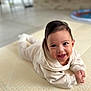 Eden a rejoint le concours — aidez-le/la à gagner de superbes lots ! baby, smiling, tummy, mat, beige_outfit, indoors, child, cute, happy, face, infant, portrait, cozy, young_child, skin, hair, hands, floor, blurred_background, eyes