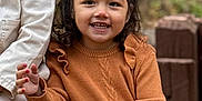Janay is registered to the contest to win money with this photo: casual_clothing, child, curly_hair, cute, daylight, face, fall, fun, happy, nature, orange_sweater, outdoor, person, portrait, sitting, smiling, striped_pants, warm_colors, wooden_steps, young_child