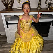 Janay joined the competition — help win amazing prizes! bow, cabinet, child, decor, dress, duck_face, floor, flooring, furniture, girl, home_interior, indoor, peace_sign, person, playful, posing, princess_costume, smiling, yellow_dress, young_child
