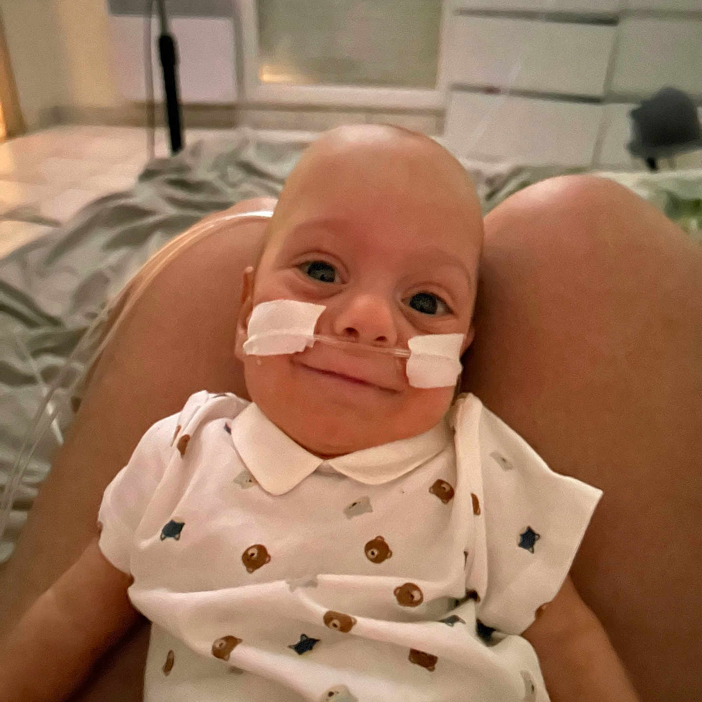 Maël participe au concours pour gagner de l'argent avec cette photo : baby, bear_pattern, bed, blanket, child, comfort, cozy, cute, healthcare, human, indoor, infant, legs, medical, nasal_cannula, person, portrait, smile, star_pattern, white_shirt