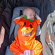 Temperance is registered to the contest to win money with this photo: baby, infant, sleeping, pumpkin_costume, orange, stroller, baby_clothing, footwear, peaceful, cute, child, portrait, sunlight, resting, holiday, costume, baby_accessory, infant_clothing, baby_boy, baby_girl