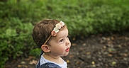 Kylie is registered to the contest to win money with this photo: toddler, child, flower_headband, blue_dress, white_shirt, forest, outdoor, greenery, nature, curious, portrait, side_profile, young_child, person, daylight, leaves, ground, exploration, innocence, cute