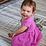 Kylie is registered to the contest to win money with this photo: toddler, child, pink_dress, smiling, sitting, indoor, carpet, toy, plush_cat, happy, cute, baby, person, portrait, floor, hair, face, clothing, skin, eyes