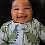 Kyzeir Walker is registered to the contest to win money with this photo: baby, smiling, dinosaur_onesie, curly_hair, child, infant, happy, portrait, couch, soft_lighting, cute, young_child, indoors, clothing, face, hands, cozy, comfort, closeup, expression