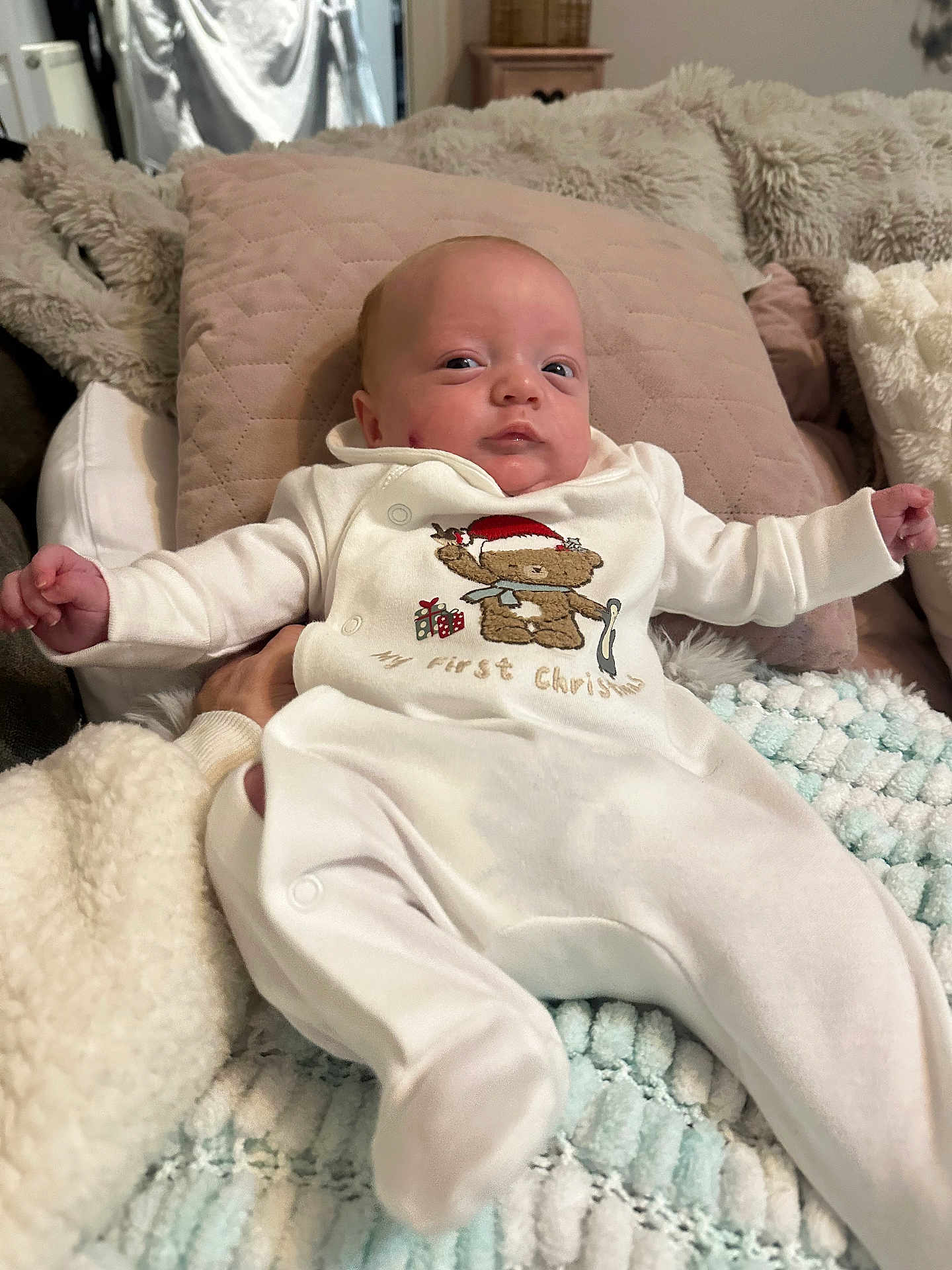 Ennis joined the competition — help win amazing prizes! baby, infant, onesie, white_clothing, teddy_bear, blanket, pillow, soft_texture, indoor, child, cute, newborn, relaxed, lying_down, cozy, holiday_theme, plush, comfortable, person, portrait