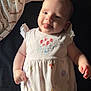 baby, infant, tongue_out, smile, light_skin, onesie, patterned_clothing, blanket, baby_wipes, soft_light, lying_down, cute, playful, indoor, child, young, happy, person, fabric, cozy