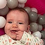 Heidi joined the competition — help win amazing prizes! baby, child, smiling, face, hand, fingers, onesie, floral_pattern, ball_pit, plastic_balls, pink, gray, white, cheek, happy, infant, cute, indoors, portrait, play