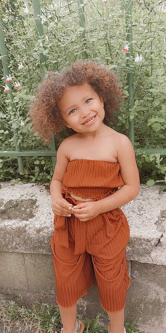 Kelsea a rejoint le concours — aidez-le/la à gagner de superbes lots ! eye, face, fawn, flash_photography, grass, hair, happy, head, joy, leaf, long_hair, people_in_nature, person, plant, skin, sleeve, smile, standing, toddler, trunk