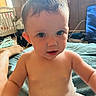 Letty is registered to the contest to win money with this photo: toddler, child, baby, indoor, bed, blanket, crib, curly_hair, blue_eyes, skin, diaper, person, furniture, foot, room, wood_paneling, window, daylight, casual, portrait