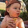 child, toddler, hat, food, chocolate, outdoor, garden, greenery, sunlight, skin, face, hands, summer, snack, cute, baby, necklace, playing, expression, casual