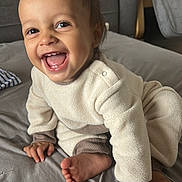 Lovannah a rejoint le concours — aidez-le/la à gagner de superbes lots ! brown, child, couch, cozy, crawling, cream, face, foot, furniture, gray, hand, happy, home, indoors, pajamas, person, pillow, smiling, soft, toddler