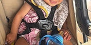 Lovannah participe au concours pour gagner de l'argent avec cette photo : toddler, stroller, child, baby_bottle, toy, smile, safety_harness, clothing, sock, seat, indoor, person, cute, happy, baby, head, face, hand, foot, play