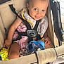 toddler, stroller, child, baby_bottle, toy, smile, safety_harness, clothing, sock, seat, indoor, person, cute, happy, baby, head, face, hand, foot, play