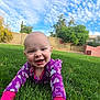 baby, smiling, purple_onesie, grass, outdoor, crawling, happy, child, sky, clouds, greenery, tree, backyard, sunny, face, infant, nature, playful, cute, daytime