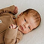 newborn, baby, infant, face, clothing, brown, ribbed, hands, lying_down, blanket, soft_texture, peaceful, portrait, closeup, skin, head, expression, cute, child, indoors