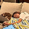girl, dog, couch, blanket, sleeping, resting, indoor, laptop, relaxation, brown_dog, white_shirt, home, cozy, technology, furniture, comfort, nap, human, pet, calm