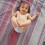 Willow Mae joined the competition — help win amazing prizes! baby, toddler, diaper, smiling, child, striped_blanket, indoor, playful, feet, hair, cute, lying_down, happy, infant, person, skin, blanket, striped, floor, relaxed