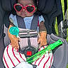 Rise is registered to the contest to win money with this photo: baby, car_seat, sunglasses, headband, bow, striped_pants, white_socks, bubble_wand, outdoor, grass, child, cute, fashion, sunny, accessory, seatbelt, infant, portrait, relaxing, summer