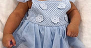 Rise is registered to the contest to win money with this photo: baby, infant, blue_dress, headband, cute, lying_down, blanket, soft_texture, chubby_cheeks, curious_eyes, portrait, child, adorable, newborn, small_hands, small_feet, indoors, closeup, fashion, smiling