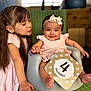 baby, child, infant, toddler, girl, smile, headband, pink_dress, baby_seat, wicker_chair, happy, cute, family, indoor, portrait, love, playing, sibling, celebration, milestone