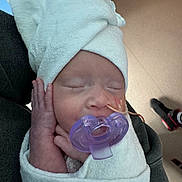 Alice Ophelia is registered to the contest to win money with this photo: baby, newborn, pacifier, towel, head_wrap, sleeping, hand, face, skin, hospital, medical_tube, wrapped, closeup, infant, peaceful, person, cute, resting, indoors, soft