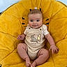 baby, child, smile, face, eyes, knitted_outfit, winnie_the_pooh, yellow_chair, fluffy_chair, indoor, cute, sitting, happy, plush, infant, person, short_hair, cozy, comfortable, clothing