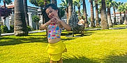 Eva joined the competition — help win amazing prizes! child, girl, smiling, playful, yellow_skirt, colorful_top, palm_trees, grass, sunny, outdoor, blue_sky, hanging_chair, boy, vacation, summer, happy, nature, park, leisure, fun