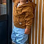 Marceau a rejoint le concours — aidez-le/la à gagner de superbes lots ! toddler, child, boy, hoodie, jeans, sneakers, door, window, carpet, wood_paneling, indoor, standing, smiling, playful, casual_clothing, curly_hair, face, person, young_child, home_interior